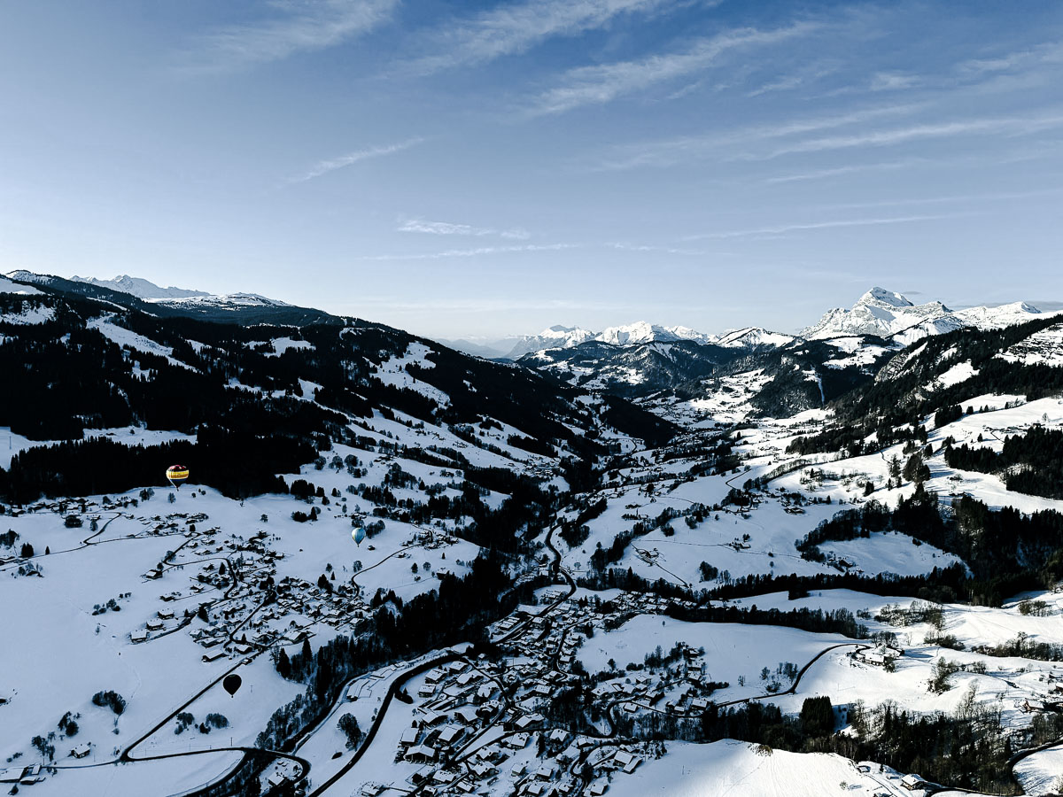 view from hot air balloon of houses covered in snow